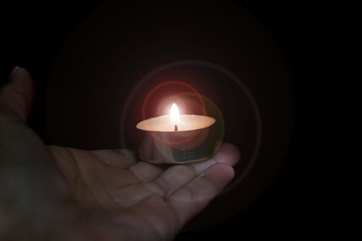 Candle in a hand close up in the dark