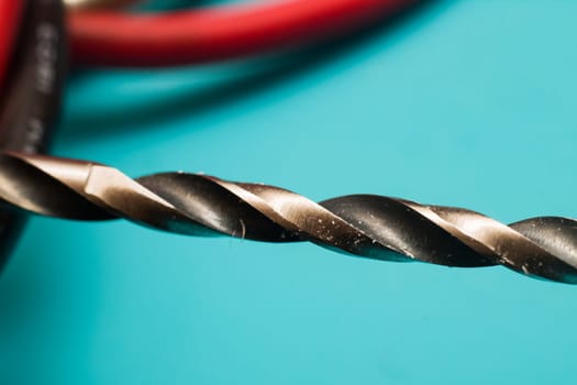 Drill bit close up on blue background, macro photo