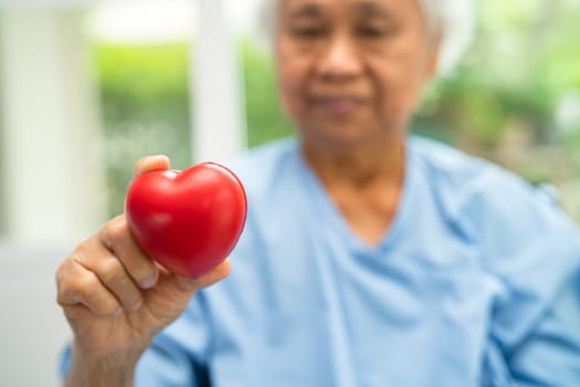 Doctor holding a red heart in hospital, healthy strong medical concept.