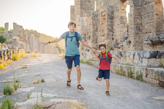 dad and son tourists at the ruins of ancient city of Perge near Antalya Turkey. Traveling with kids concept.