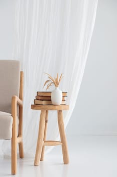 Wooden handcraft chair with books and vase on a white background