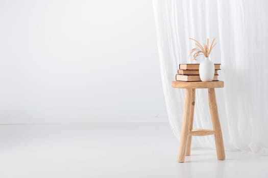 Wooden handcraft chair with books and vase on a white background