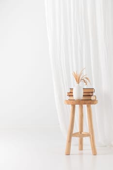 Wooden handcraft chair with books and vase on a white background