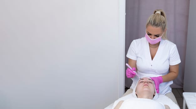 Banner Cosmetologist Making Mesotherapy Injection With Dermapen On Face Of Beautiful Young Woman For Rejuvenation In Spa Saloon. Patient Getting Needle Mesotherapy, Skincare. Horizontal Copy Space.