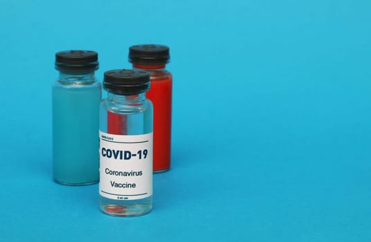Glass bottle with covid-19 vaccine, blood bottle, blue liquid bottle. pharmaceutical concept.