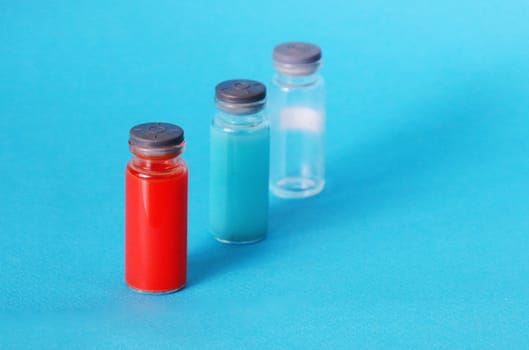 Red, blue and empty medical bottle on a blue background. Medical pharmaceutical concept...