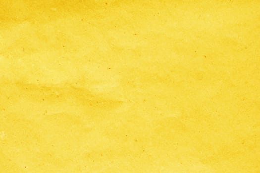 Cardboard background made of natural crumpled yellow paper.