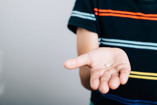 Child's hand holding a fallen baby tooth portrays dental hygiene. First lost tooth signifies a toddler's development and joy. Children show teeth new gap, dentist problems