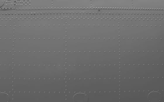 Aircraft skin close up. Rivets on gray metal. Aluminum surface of the aircraft fuselage. ..Abstract metal background.
