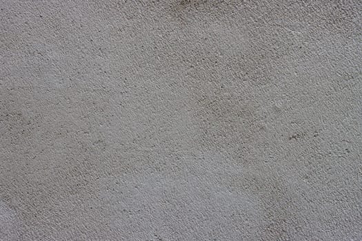 Abstract background of a gray concrete wall unevenly plastered and covered with cement.....