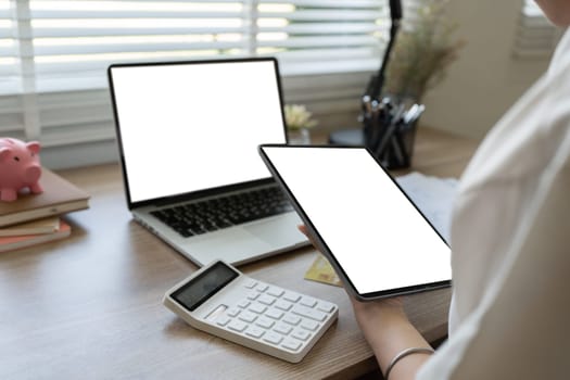 Women use tablet and notebook to manage financial information. Mockup tablet and laptop.
