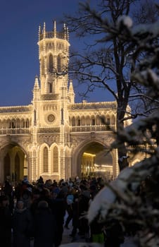 Russia, Peterhof, St.Petersburg, 07 January 2024: Magical illumination of the building of the New Peterhof railway station near St. Petersburg on a winter evening, Christmas decorations on trees. High quality photo