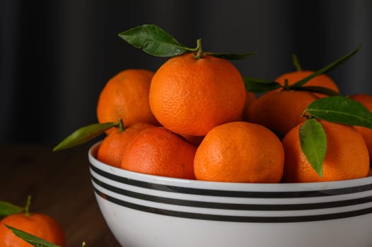 fresh juicy tangerines in a white bowl on a wooden table 3