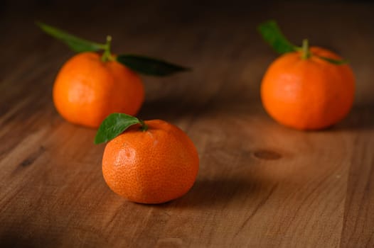 fresh juicy three tangerines on a wooden table 4