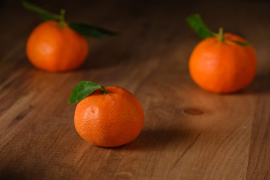 fresh juicy three tangerines on a wooden table 3