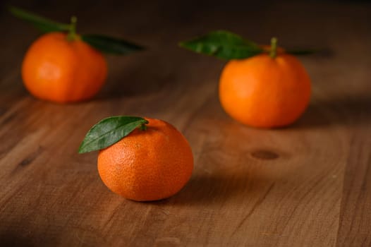 fresh juicy three tangerines on a wooden table