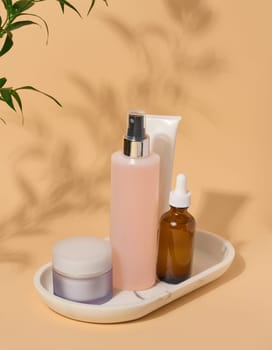 Set of facial care cosmetics on a beige background. Tonic, cream, lotion and oil
