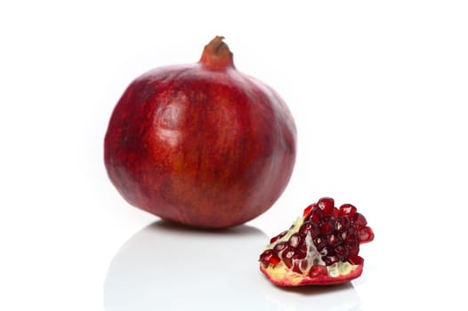 pomegranate and pomegranate slice on a white background