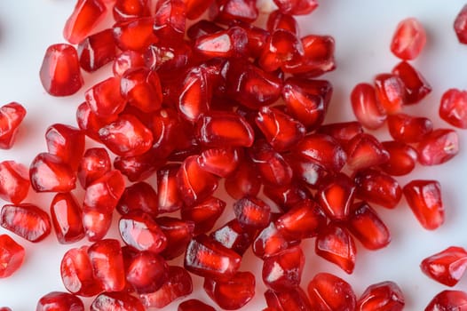 juicy pomegranate seeds on white background