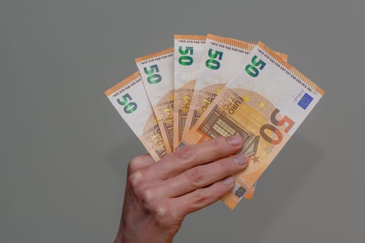 50 euro bills in hand on gray background 1