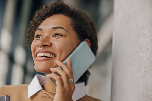 Smiling female freelancer is talking phone with client while standing on coworking background