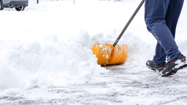 Man shoveling snow off of his driveway after a winter storm in Canada. Man with snow shovel cleans sidewalks in winter. Winter time