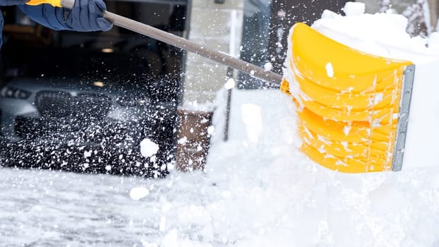 Man shoveling snow off of his driveway after a winter storm in Canada. Man with snow shovel cleans sidewalks in winter. Winter time