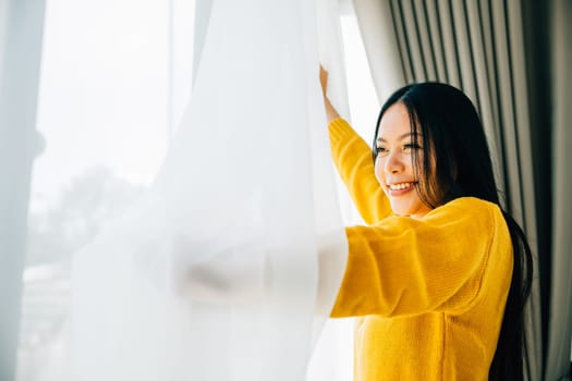 A young woman awakens early opens curtains smiles at the view feeling refreshed and happy at home. Embracing relaxation joy and morning freshness with a cheerful face.