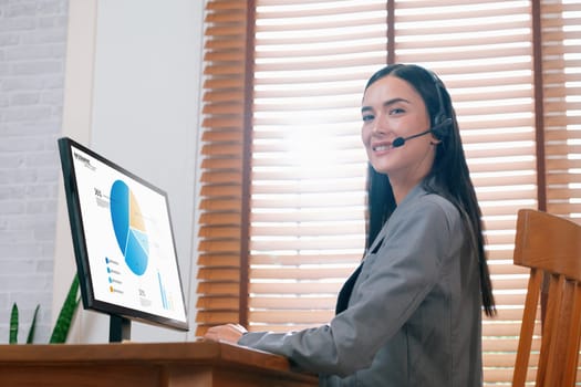 Female call center operator or telesales with headset using laptop for online meeting on business marketing display financial infographic, planning strategic marketing and increase sales. Blithe