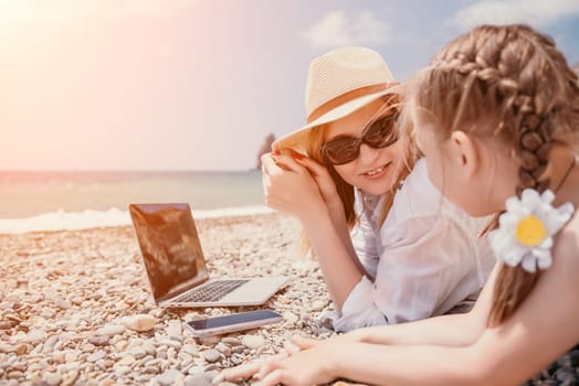 Woman sea laptop. Business woman in yellow hat working on laptop by sea. Close up on hands of pretty lady typing on computer outdoors summer day. Freelance, digital nomad, travel and holidays concept.