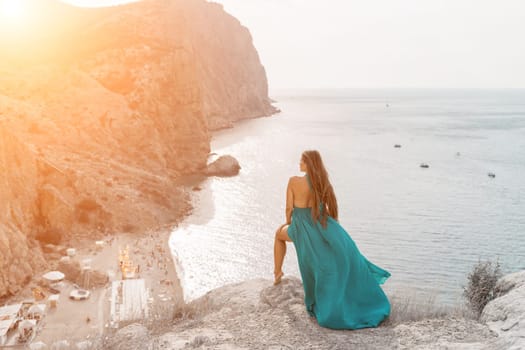 Woman sea trevel green dress. Side view a happy woman with long hair in a long mint dress posing on a beach with calm sea bokeh lights on sunny day. Girl on the nature on blue sky background