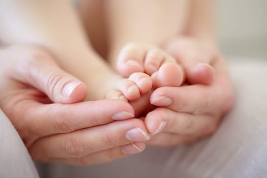 Love, mother and hands with baby or feet for development, nurture and bonding in nursery of apartment. Family, woman or newborn toes with relax, support or care for relationship or motherhood in home.