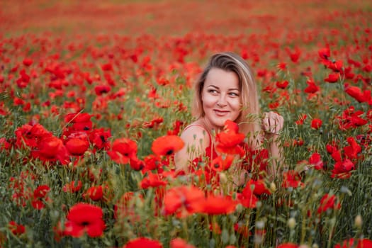 Happy woman in a red dress in a beautiful large poppy field. Blond sits in a red dress, posing on a large field of red poppies.