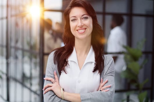 Portrait of a serious lady posing against the backdrop of a modern office.