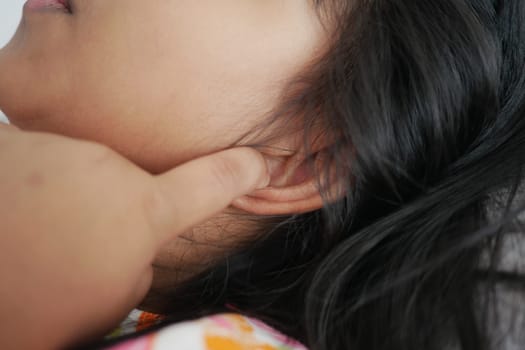 child having ear pain touching his painful ear