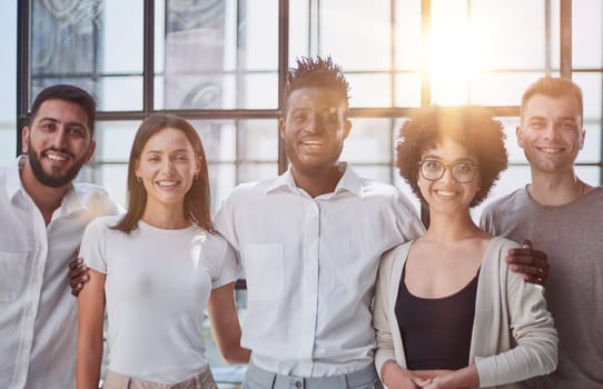 Portrait of successful creative business team looking at camera and smiling. Diverse business people standing together at startup.