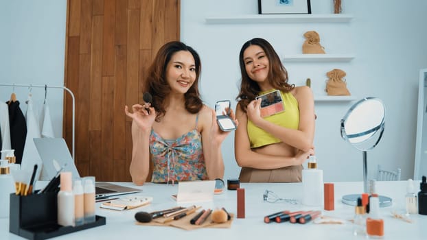 Two influencer partner shoot live streaming vlog video review makeup social media or blog. Happy young girl with vivancy cosmetics studio lighting for marketing recording session broadcasting online.