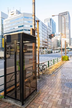 Tokyo, Japan, January 2024. a public telephone booth on the pavement of a street in the city center