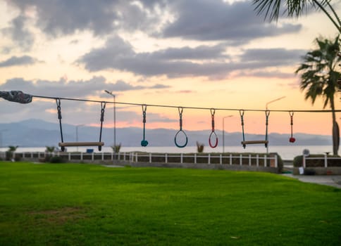 children's entertainment - rings, swings, stairs against the backdrop of sunset 1