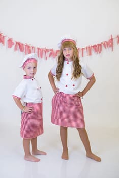 children with red and white chef's hat and apron. children cooking, healthy eating.