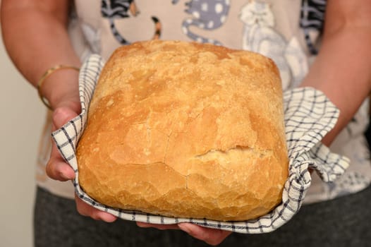 freshly baked bread at home in the hands of a woman in the kitchen 4