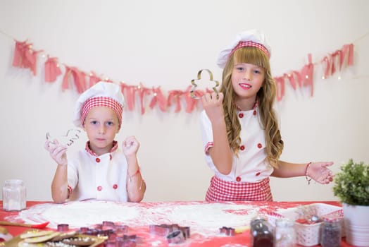 happy smiling children in apron and chef hat cooking cookies with flour, eggs, chocolate and water. Kitchen and family. Happy kids.