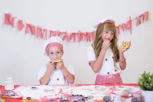 happy smiling children in apron and chef hat cooking cookies with flour, eggs, chocolate and water. Kitchen and family. Happy kids.