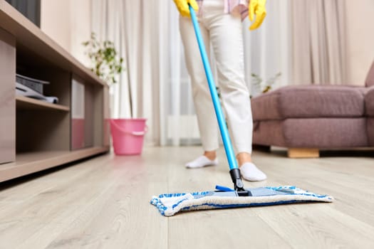 young woman cleaning and mopping floor at living room, daily housekeeping , close-up