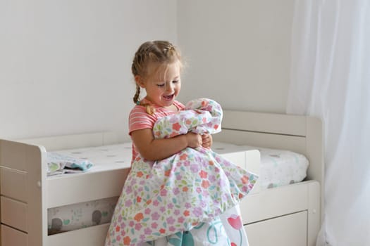 A girl makes a bed in the children room