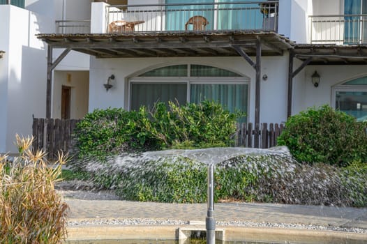 a fountain sprays water against the backdrop of a residential complex near the sea 2