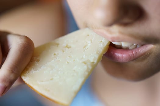 From above closeup of crop anonymous teenage girl eating fresh cheese at home