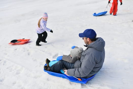 The father with child sledding in the snow