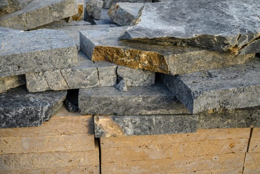 pieces of stone for paving lie in a heap as a background