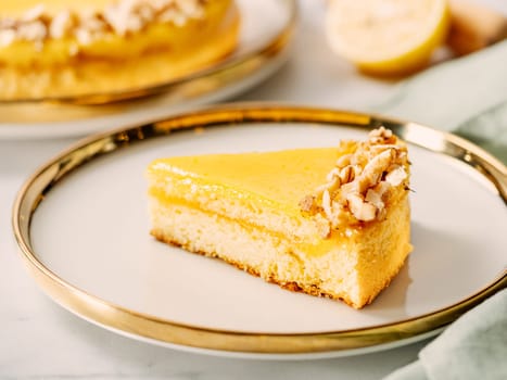 Piece of delicious lemon tart or lemon cake, modernly decorated with walnuts on aesthetic plate. Aesthetic of traditional classic french lemon pie with lemon curd recipe. Copy space